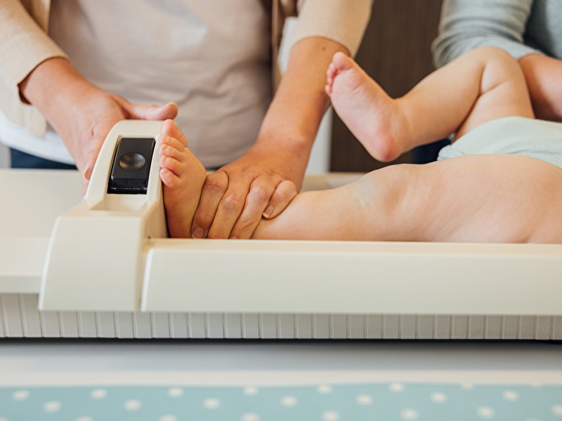 Jong JGZ consultatiebureau: baby wordt gemeten door de assistente